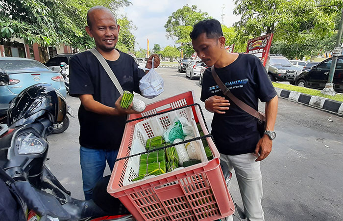 DIGEMARI PEJABAT: Penjual tempe Boni Agung Kristanto, warga Padukuhan Balong, Hargomulyo, Gedangsari saat melayani pembeli di parkiran kantor Pemkab Gunungkidul beberapa waktu lalu.
