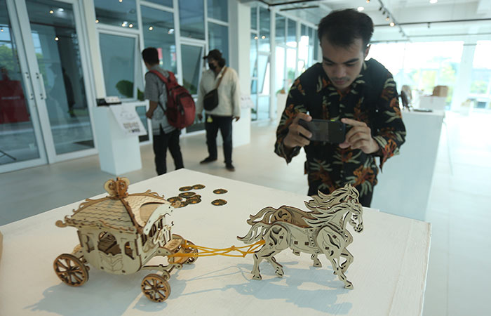 DETAIL: Pengunjung saat memotret salah satu karya dalam pameran Jogja Design Merch di PDIN Rabu(14/6/23).