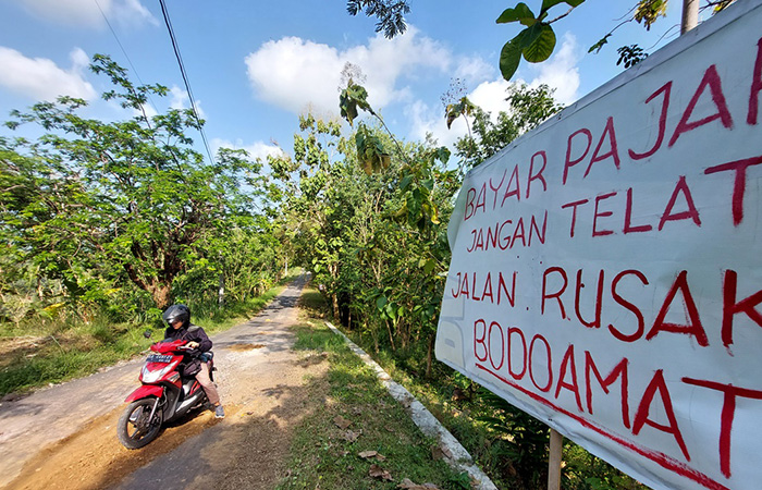 RUSAK PARAH: Spanduk terpasang di ruas jalan penghubung Kalurahan Sidomulyo (Kapanewon Pengasih) dengan Jatimulyo (Kapanewon Girimulyo) Kulonprogo, Jumat (23/6/23).
