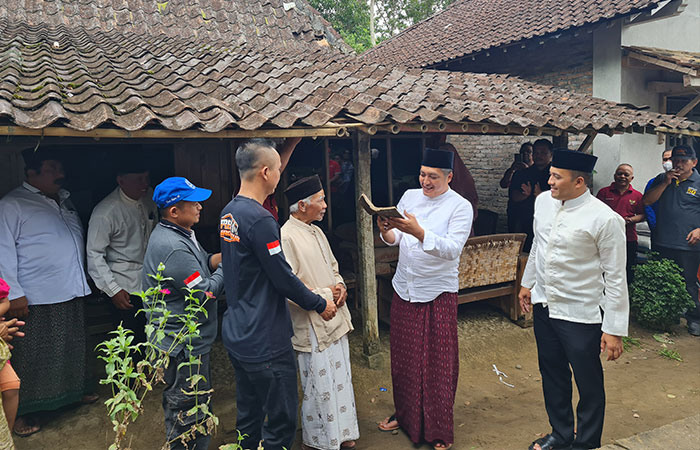 GOTONG ROYONG: Bupati Magelang secara simbolis memberikan genteng yang hendak direnovasi.