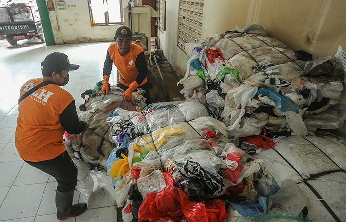 Petugas menata residu sampah plastik yang telah dipres.
