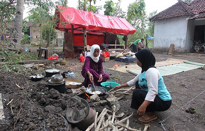 SIAPKAN KONSUMSI- Warga Warga memasak di halaman akibat rumahnya rusak pascagempa Bantul, di Pacarejo, Semanu, Gunungkidul, DIJ. Foto diambil Minggu (1/7/23) lalu.