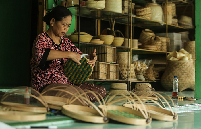 Pengrajin melakukan finishing anyaman tudung saji dari bambu di Desa wisata Brajan, Minggir, Sleman, Jumat (7/7/23).