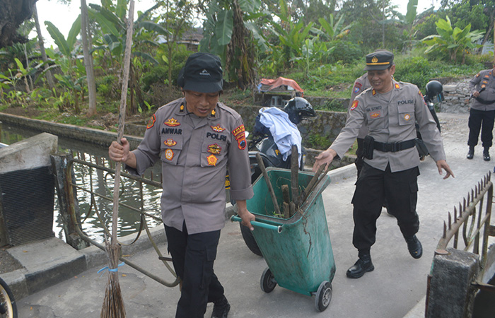 RERESIK: Para personel Polres Magelang Kota bersama warga setempat bekerja sama membersihkan area publik, Kamis (13/7/23).