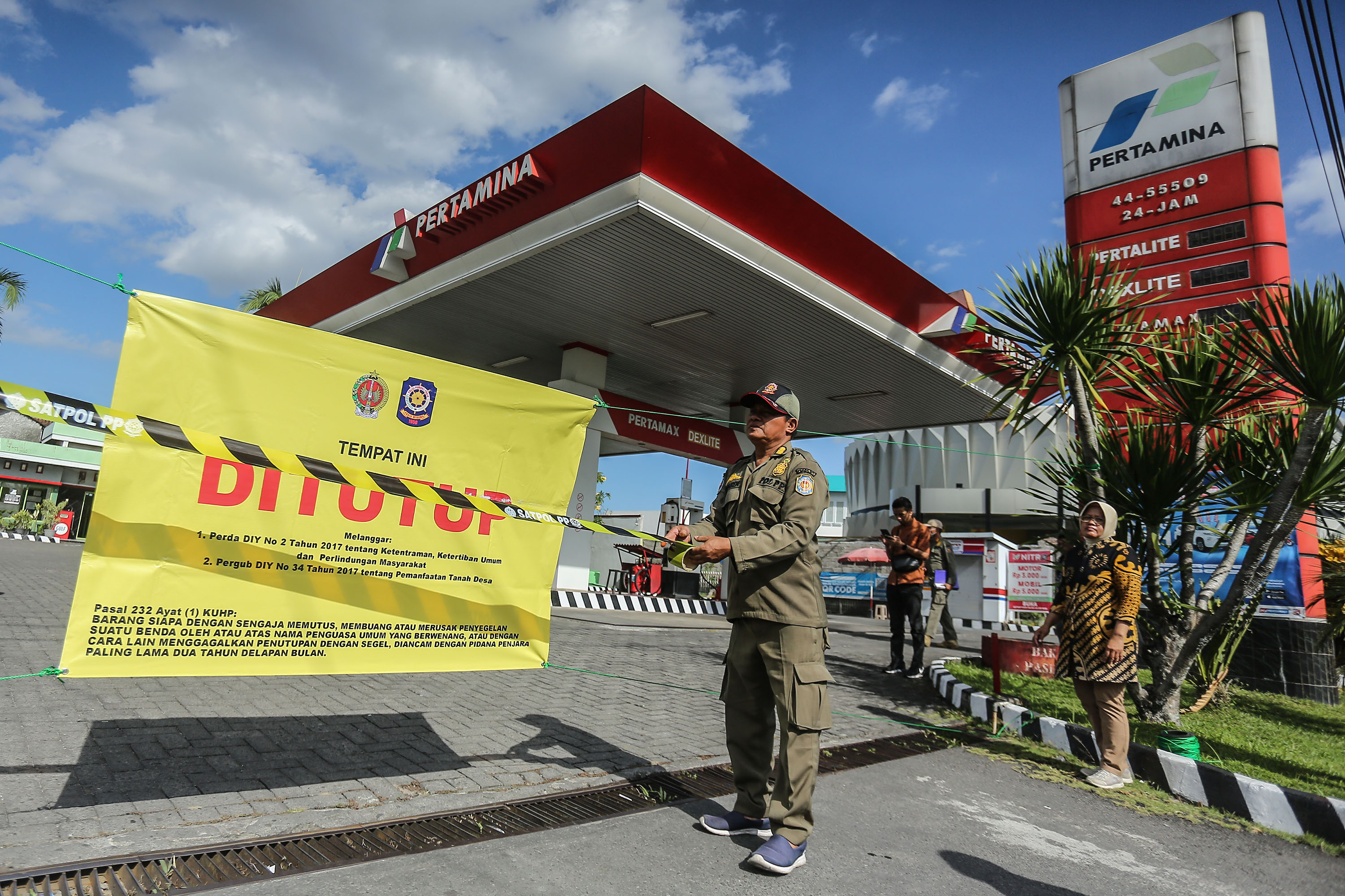 Petugas Satpol PP DIJ menyegel SPBU yang tak berizin di kawasan Jalan Tentara Pelajar, Sariharjo, Ngaglik, Sleman, kamis (20/7). SPBU yang berdiri di tanah kas desa sejak 2001 itu tidak mengurus perpanjangan izin selama 2 tahun. Selain SPBU Satpol PP DIJ