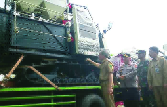 UNTUK KADANG TANI: Bupati Bantul Abdul Halim Muslih menyirami mesin combine harvester dengan air kendi. Harapannya, alsintan bantuan itu bermanfaat untuk para petani.