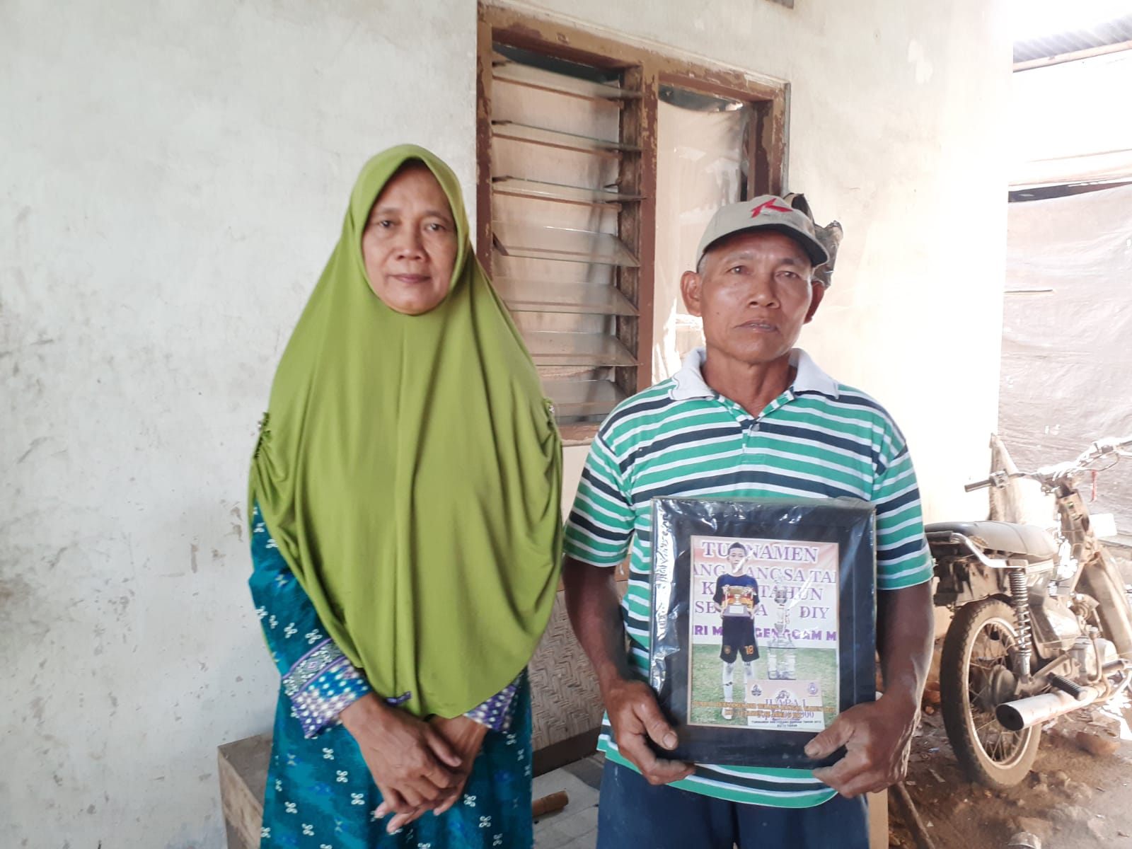 BANGGA: Tugiyo,59 dan Sutini,64 saat menunjukkan foto anaknya yang diterima sebagai polisi. (Iwan Nurwanto/Radar Jogja)