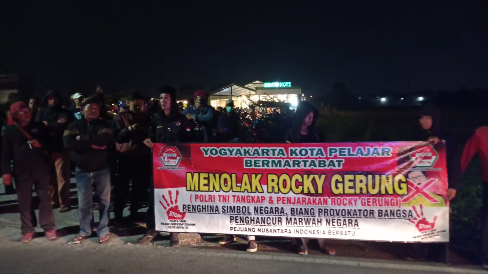 TOLAK: Sejumlah warga membentangkan spanduk menolak kehadiran Rocky Gerung di Bento Kopi Godean, Sleman, Rabu malam (2/8). (Istimewa)