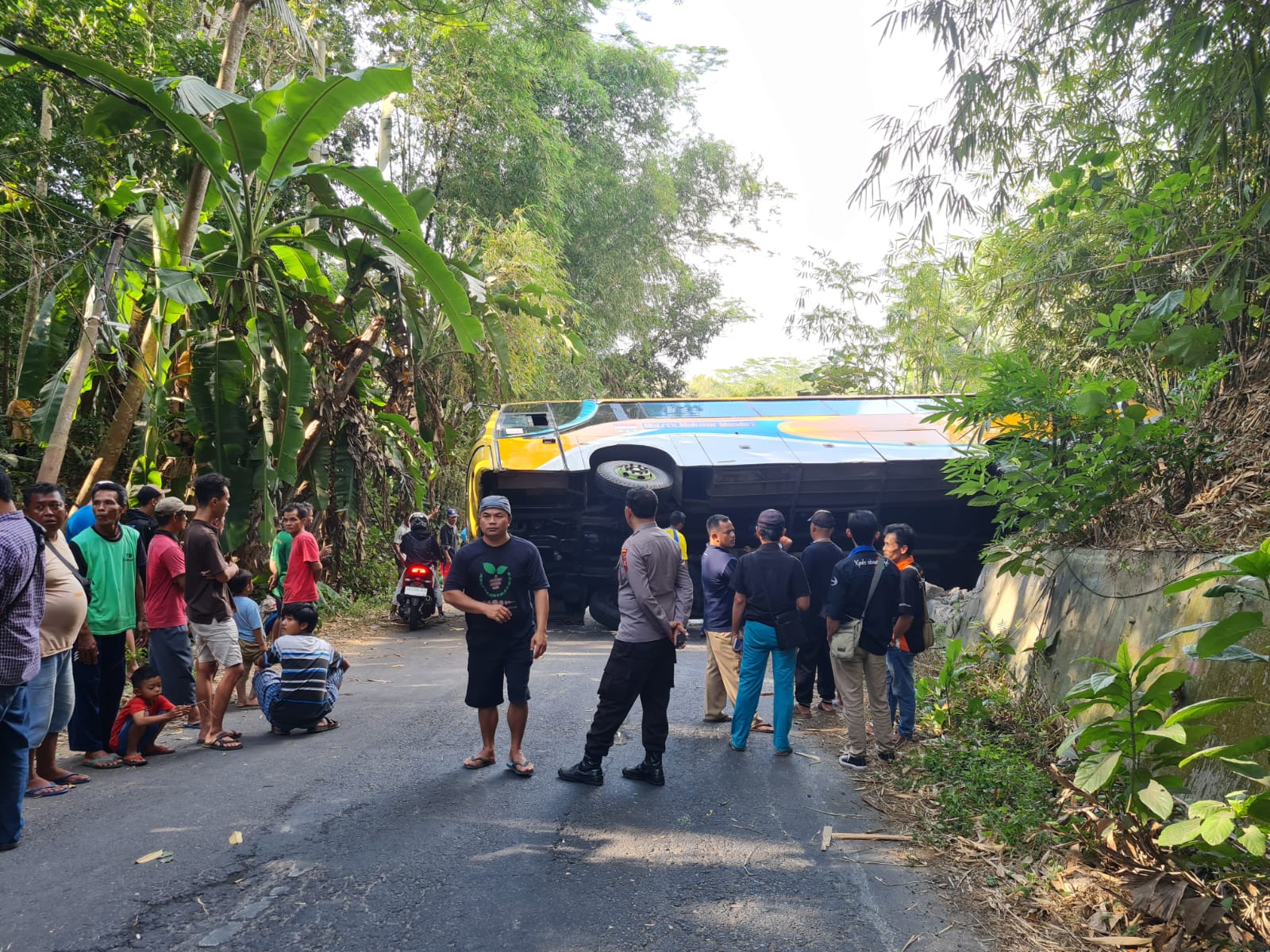 HALANGI JALAN: Bus tanpa penumpang terguling di jalan penghubung antara Tempuran-Borobudur, Senin siang (7/8). (Naila Nihayah/Radar Jogja)