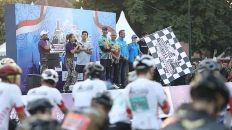 SPORT: Gubernur Jateng Ganjar Pranowo dan Wali Kota Solo Gibran Rakabuming Raka melepas peserta Tour de Borobudur XXIII hari pertama dari parkir Pura Mangkunegaran, Sabtu (5/8). (Radar Solo)