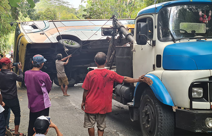 EVAKUASI: Proses evakuasi badan bus yang terguling di Jalan Tempuran-Borobudur berjalan sukses, Senin sore (7/8). Sebelumnya, badan bus menghalangi akses kendaraan.