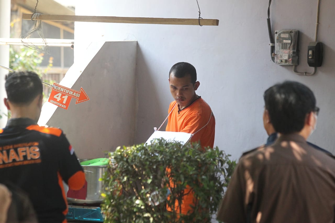 ADEGAN: Tersangka mutilasi Waliyin saat rekonstruksi di kos-kosan di Padukuhan Krapyak, Triharjo, Sleman, Selasa (8/8). (GUNTUR AGAR TIRTANA/RADAR JOGJA)