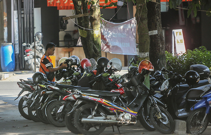 RAPI: Juru parkir merapikan motor di Kawasan Lapangan Denggung, Sleman Kamis (10/8/23). Dishub Sleman menargetkan realisasi retribusi parkir 2023 sebesar Rp 2,5 miliar.
