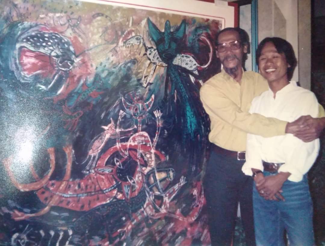 FOTO KENANGAN: Momen Klowor Waldiyono dirangkul Djoko Pekik berlatar belakang lukisan ekspresif fauna, tahun 1994. (Facebook Klowor Waldiyono)