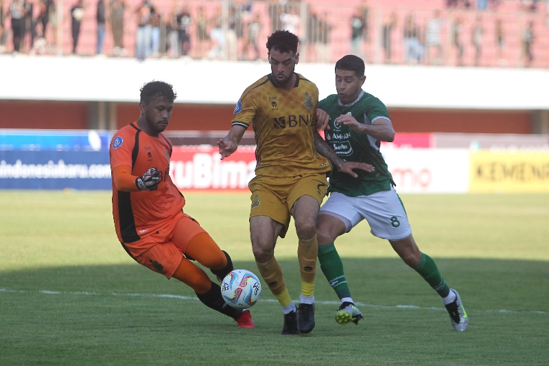 YAKIN: Pemain PSS Esteban Vizcarra (kanan) berebut bola dengan bek dan kiper Bhayangkara FC Alef Santos dan Aqil Savik dalam Liga 1 di Stadion Maguwoharjo (13/8). (Guntur Aga Tirtana/Radar Jogja)