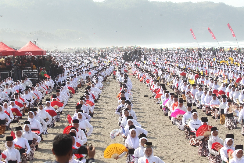 PUSAT MONTRO; Ribuan siswi serempak membawakan Tari Montro di Pantai Parangkusumo, Bantul, Sabtu (26/8). (Guntur Aga Tirtana/Radar Jogja)