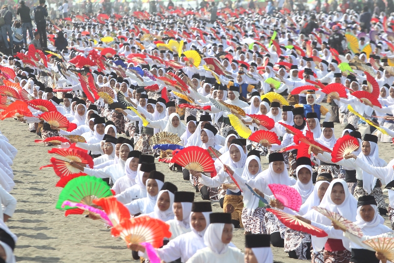 PUSAT MONTRO; Ribuan siswi serempak membawakan Tari Montro di Pantai Parangkusumo, Bantul, Sabtu (26/8). (Guntur Aga Tirtana/Radar Jogja)
