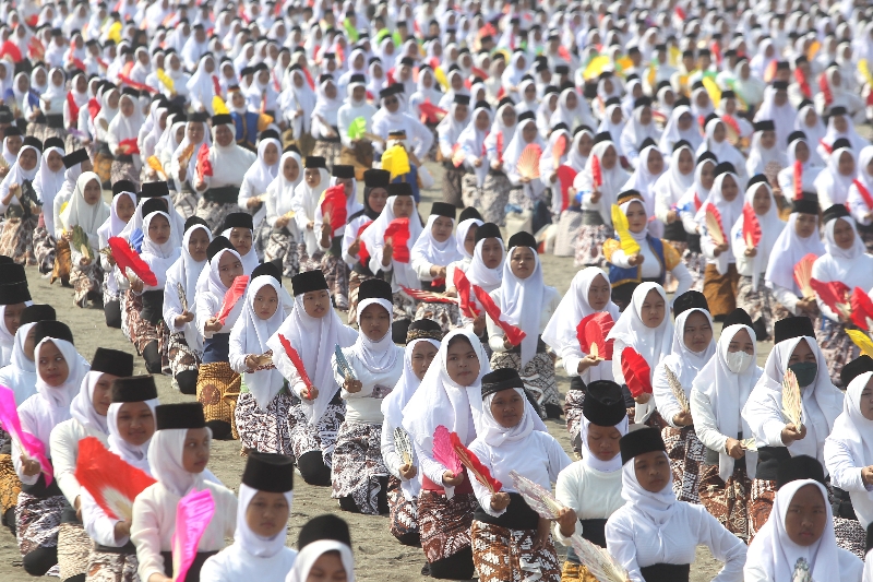 PUSAT MONTRO; Ribuan siswi serempak membawakan Tari Montro di Pantai Parangkusumo, Bantul, Sabtu (26/8). (Guntur Aga Tirtana/Radar Jogja)