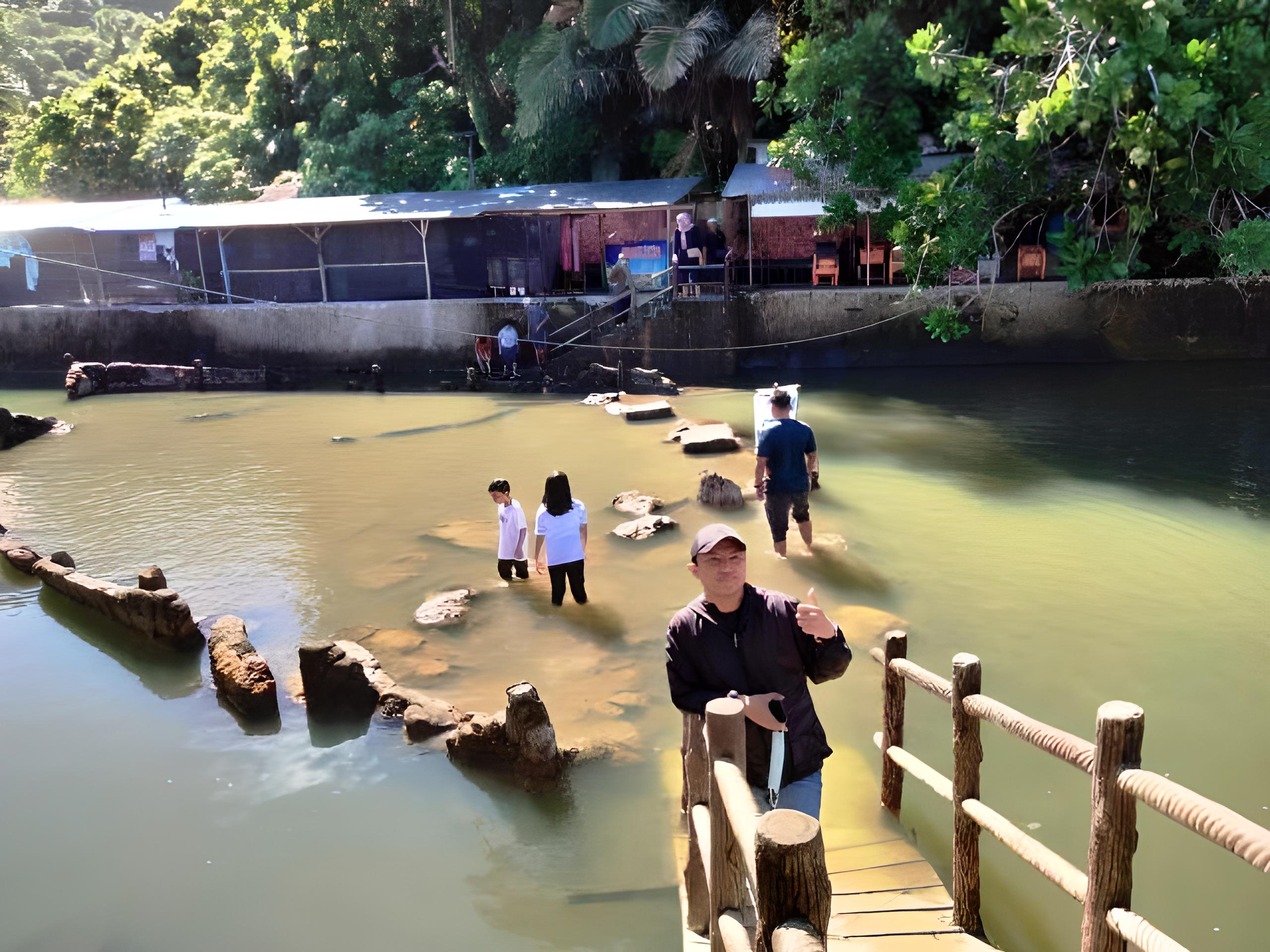 Wisatawan berfoto dengan latar belakang batu Malin Kundang di Pantai Air Manis Kota Padang, yang kini sudah menjadi seperti kolam