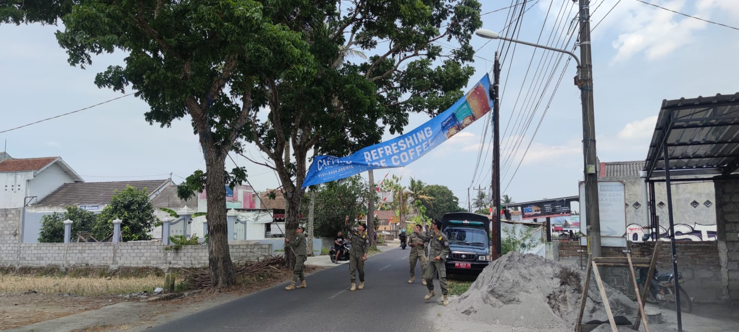 TEGAS: Petugas Satpol-PP Sleman saat melakukan penertiban spanduk dan reklame ilegal pada Senin (4/9). (DOK SATPOL PP SLEMAN)