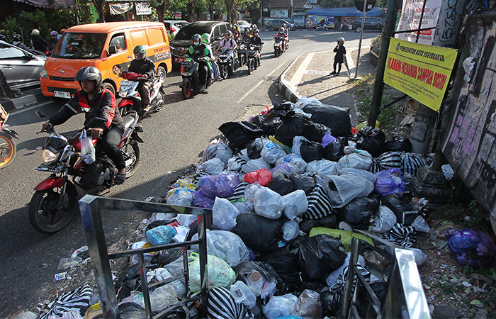 Pengguna jalan melintas di dekat tumpukan sampah yang dibuang secara sembarangan oleh warga, di Jalan Tentara Rakyat Mataram, Kota Jogja, kemarin (4/9).