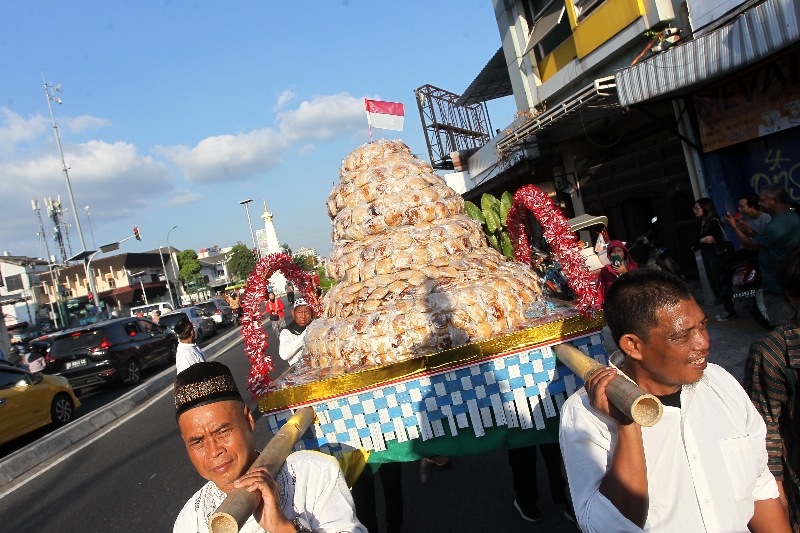 SEMARAK: Warga Gondolayu, Jetis, Kota Jogja, mengarak gunungan berisi apem melintas di kawasan Tugu Jogja Minggu (10/9) menyambut Bulan Safar dalam kalender Islam. (Guntur Aga Tirtana/Radar Jogja)