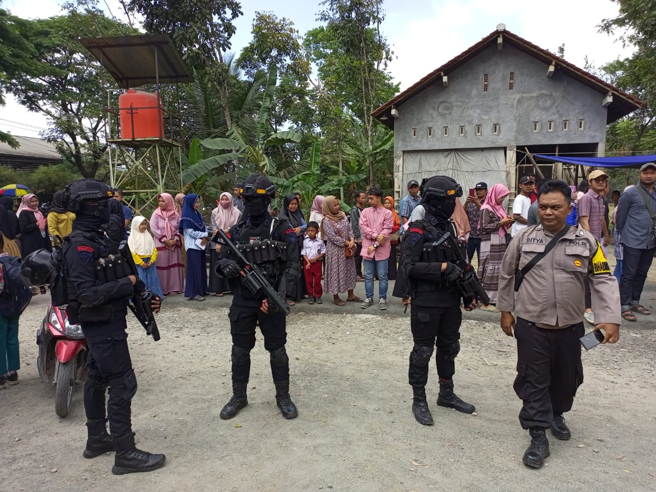SIAGA : Sejumlah personel Brimob berjaga di sekitar tempat pemungutan suara (TPS) pada pemilihan kepala desa (Pilkades) Karangpoh. (M HAFIED/RADAR KEBUMEN)