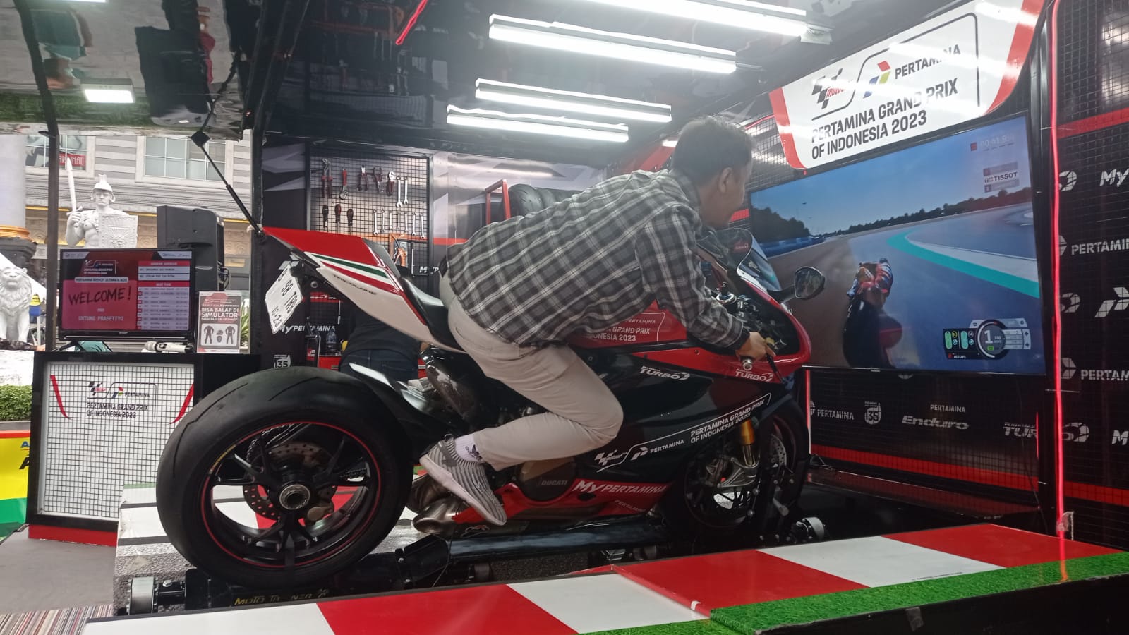 SIMULASI: Salah seorang pengunjung mencoba motor simulasi Moto GP