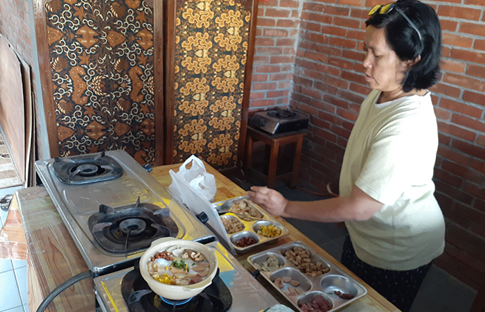 BEDA:&nbsp;Pemilik Bubur Bakar 221, Wiwik, saat menyajikan bubur bakarnya pada Jumat (15/9).IWAN NURWANTO/RADAR JOGJA