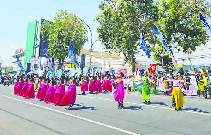 MERIAH: Para peserta karnaval dari berbagai elemen tampil memukau di depan panggung kehormatan, sisi timur Alun-alun Kota Magelang, Minggu (24/9).