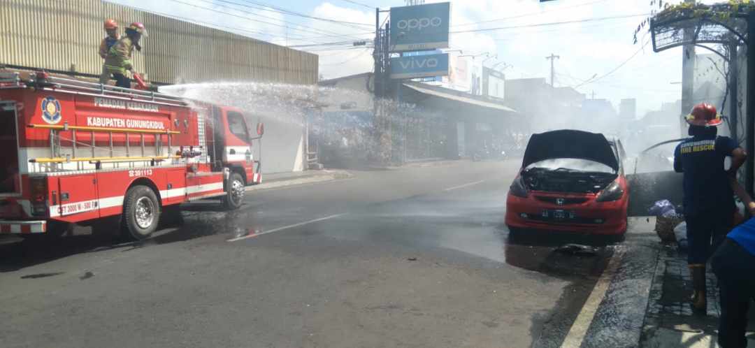 JADI ARANG - Sebuah mobil warna merah milik anggota TNI terbakar Jalan Sumarwi, Gadungsari, Wonosari Minggu (24/9)