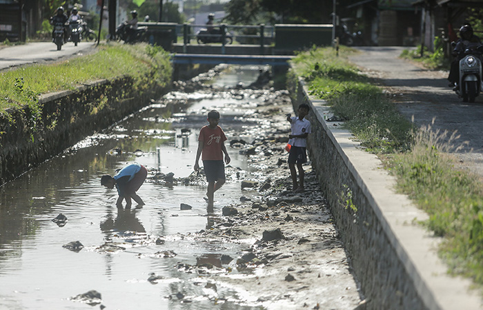 MULAI SURUT: Anak-anak sedabf mencari ikan dan udang di Selokan Mataram yang surut di kawasan Meguwo, Maguwoharjo, Depok Selasa (26/9/23).ELANG KHARISMA DEWANGGA/RADAR JOGJA
