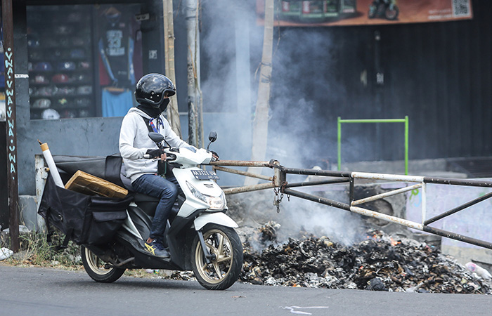 PENYEBAB POLUSI: Pengguna jalan saat melintas di samping pembakaran sampah beberapa waktu lalu.