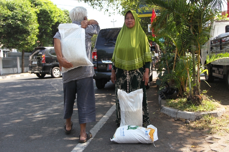 MANFAAT: Warga membawa beras dalam operasi pasar di Kota Jogja Selasa (26/8). (Guntur Aga Tirtana/Radar Jogja)