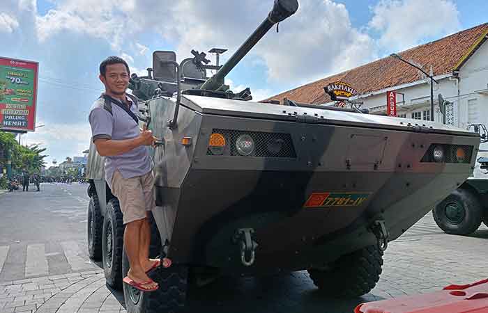 PENASARAN: Seorang warga Kota Jogja Iftahudin saat memotret momen bersama kendaraan tempur Tarantula di Jalan Sudirman, Senin (2/10).Alfi Annissa Karin/ Radar Jogja