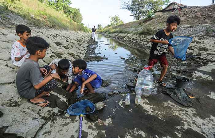 PEMELIHARAAN RUTIN: Anak-anak saat bermain di Selokan Mataram yang telah surut di kawasan Trihanggo, Gamping, Sleman Senin (2/10).ELANG KHARISMA DEWANGGA/RADAR JOGJA&nbsp;
