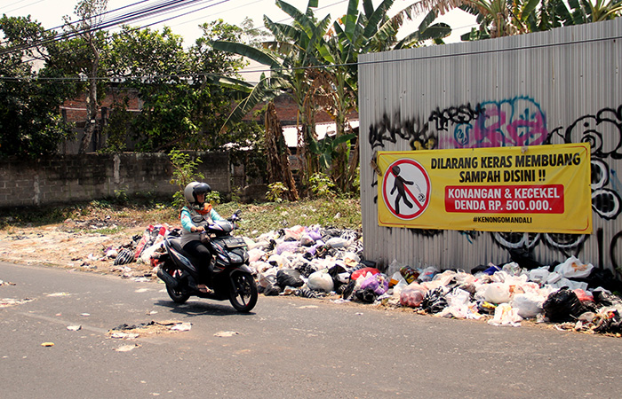 TAK ELOK: Pengendara melintas di samping tumpukan sampah yang berserakan di Jalan Bugisan Selatan, Kalurahan Tirtonirmolo, Kasihan, Selasa (5/10).Gregorius Bramantyo/Radar Jogja