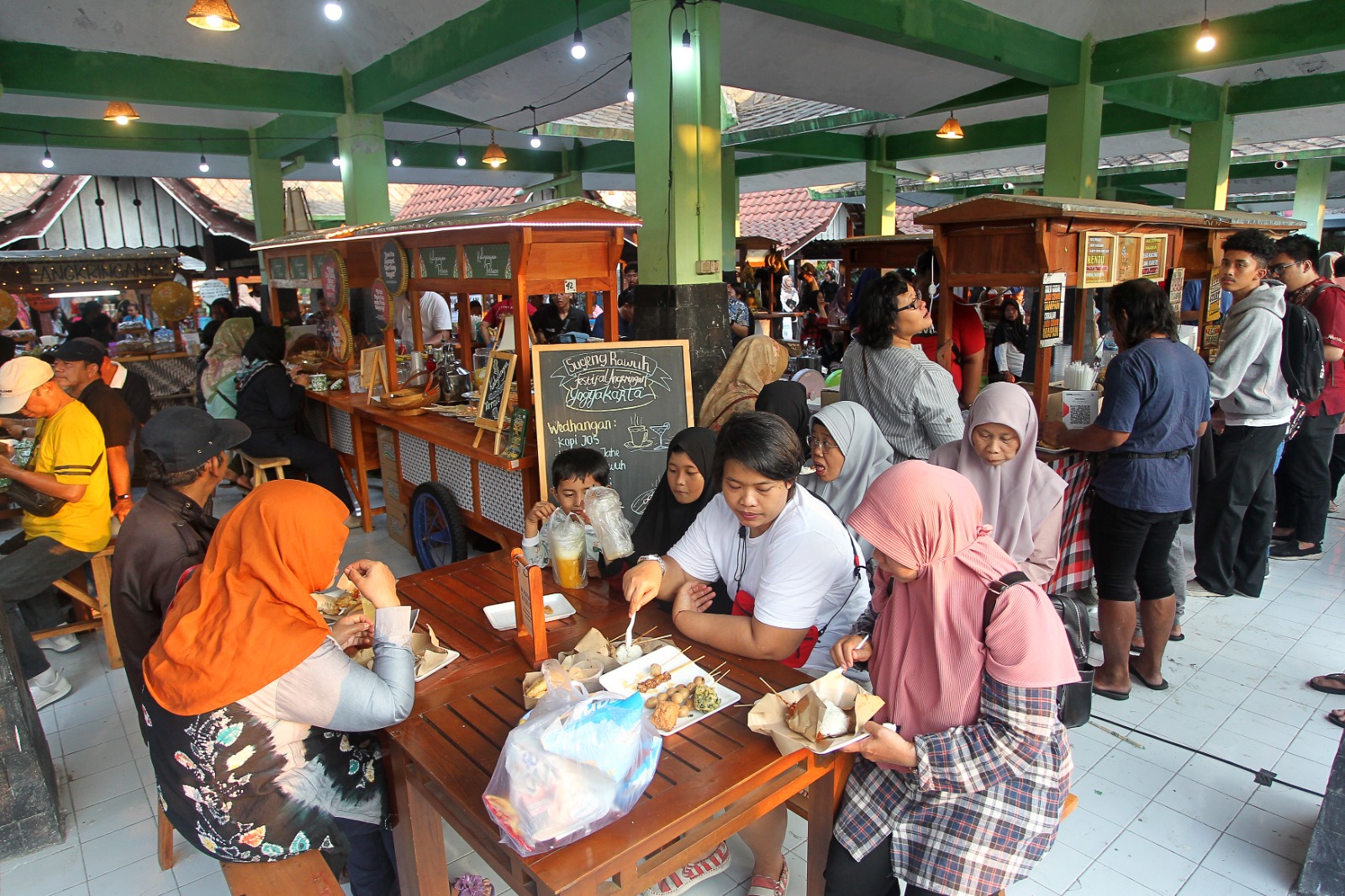MENU KHAS: Warga menikmati hidangan khas angkringan saat Festival Angkringan Jogja Plaza Ngasem, Kota Jogja, Jumat (6/10). Ada 43 angkringan yang berpartisipasi. (GUNTUR AGA TIRTANA/RADAR JOGJA)
