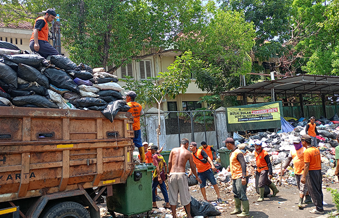 GUNUNGAN SAMPAH: Pasukan oranye DLH Kota Jogja tengah mengangkut tumpukan sampah yang menggunung di Depo Sampah Kotabaru, Senin (9/10).Alfi Annissa Karin/Radar Jogja