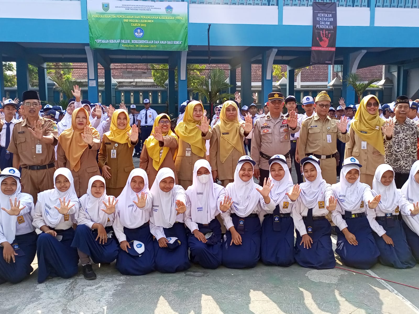KOMPAK: Kepala Dinas Pendidikan, Kepemudaan dan Olahraga (Disdikpora) Kebumen Yanie Giat Setyawan (tengah) memimpin seruan anti perundungan di lingkungan SMPN 5 Kebumen. (M HAFIED/RADAR KEBUMEN)