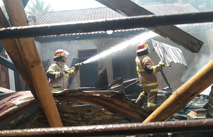 KERJA KERAS: Petugas pemadam kebakaran (Damkar) Satpol PP berjibaku memadamkan kobaran api yang menghanguskan rumah warga.ISTIMEWA