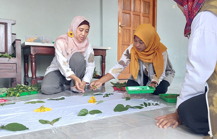 PROSPEKTIF: Proses pembuatan batik ecoprint Kelompok Batik Ecoprint Hargomulyo (kanan). Salah satu pembeli asik memilih pakaian dari bahan Batik Ecoprint Hargomulyo.HENDRI UTOMO/RADAR JOGJA