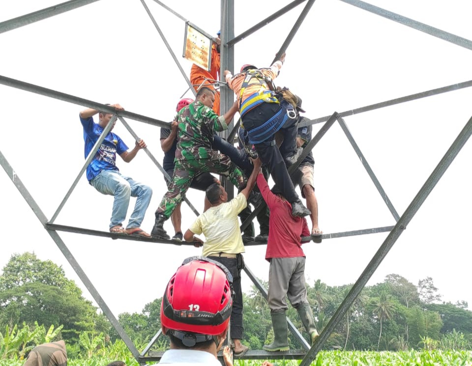 SELAMATKAN: Petugas gabungan saat melakukan evakuasi mahasiswi yang memanjat tower sutet di Widodomartani, Ngemplak, Sleman, pada Selasa (10/10). (Sok BPBD Sleman)