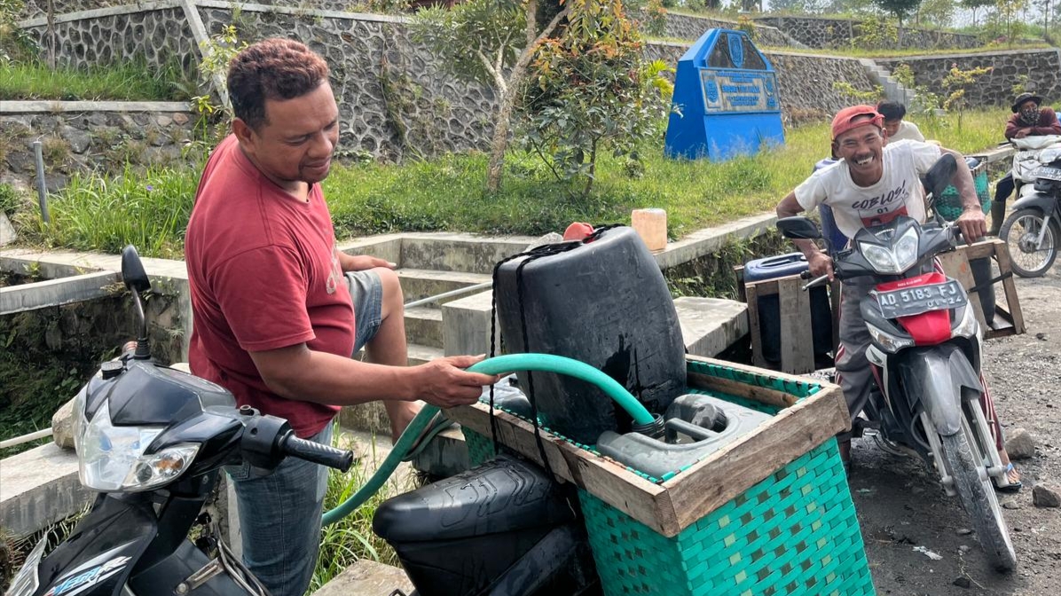 KEMARAU PANJANG: beberapa warga sedang mengantri di Embung Tirta Mulya, untuk mengisi jerigen-jerigen mereka dan membawanya dengan sepeda motor. (ISTIMEWA)
