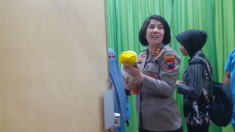 SUCI: Kapolres Magelang Kota tampak menggendong bayi laki-laki yang ditemukan warga di teras rumahnya, Kamis malam (12/10). (Dok Istimewa)