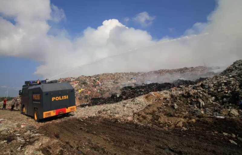 SEGALA UPAYA: Selain pemadaman dari personil dan armada damkar BPBD Bali, polisi juga membantu dengan menerjunkan Water Cannon padamkan api di TPA Suwung. (miftahuddin halim/radarbali.id)