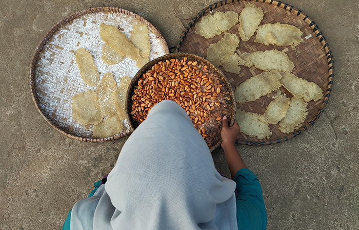 BISA UNTUK JEMUR: Seorang warga Purworejo tengah menjemur kerupuk dan kakao menggunakan tampah (20/10).JIHAN ARON VAHERA/RADAR&nbsp;JOGJA