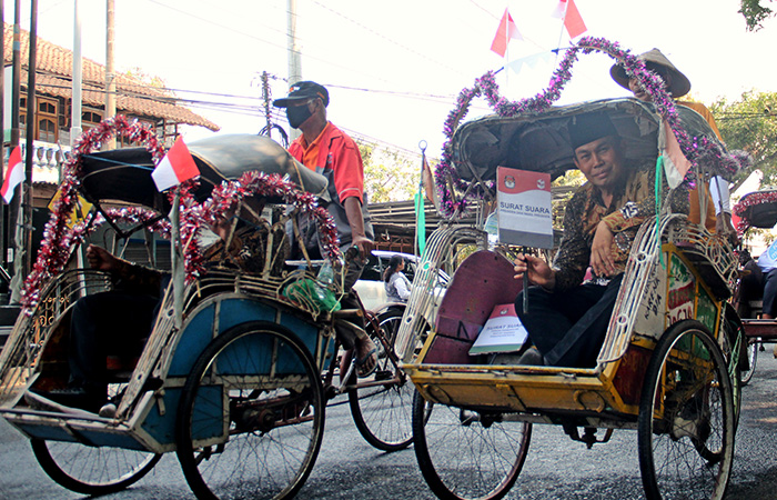 NAIK BECAK: Komisioner KPU Bantul dengan menaiki becak dalam kirab Pemilu 2024 yang digelar dari KPU Bantul ke Pendapa Parasamya Bantul, Senin (23/10).Gregorius Bramantyo/Radar Jogja&nbsp;