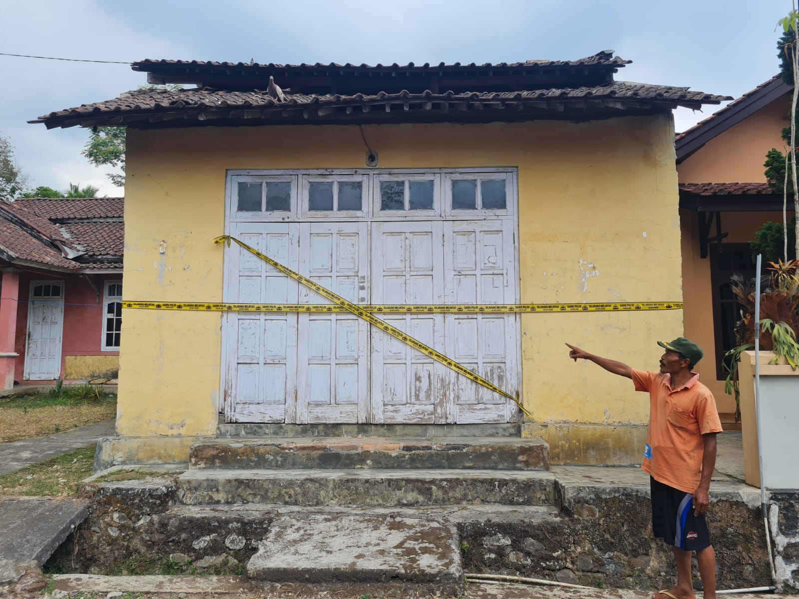 GUDANG KERIPIK: Ketua RT 07/RW 04 Dusun Temanggal 1, Desa Bumirejo, Kaliangkrik saat menunjukkan rumah produksi keripik pisang. Saat ini, kondisinya diberi garis polisi. (Naila Nihayah/Radar Jogja)