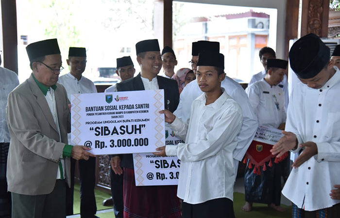 BENTUK PERHATIAN : Bupati Kebumen Arif Sugiyanto menyaksikan transaksi pengambilan beasiswa untuk santri.